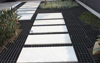 Pisos permeáveis Ecoplate drenam água da chuva em jardim de casa de alto padrão